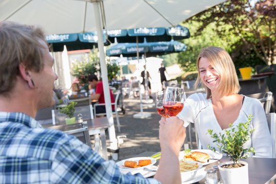 Jägerhaus Biergarten Zwei Personen stoßen mit Wein im Jägerhaus Biergarten an.